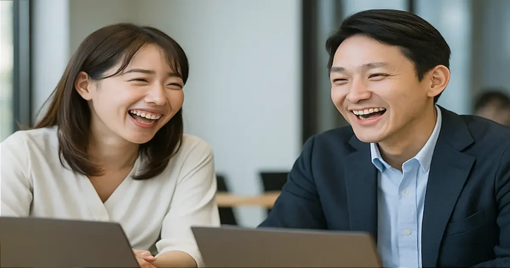 若い日本人ビジネスマンとビジネスウーマンが会話中に笑顔を交わす場面